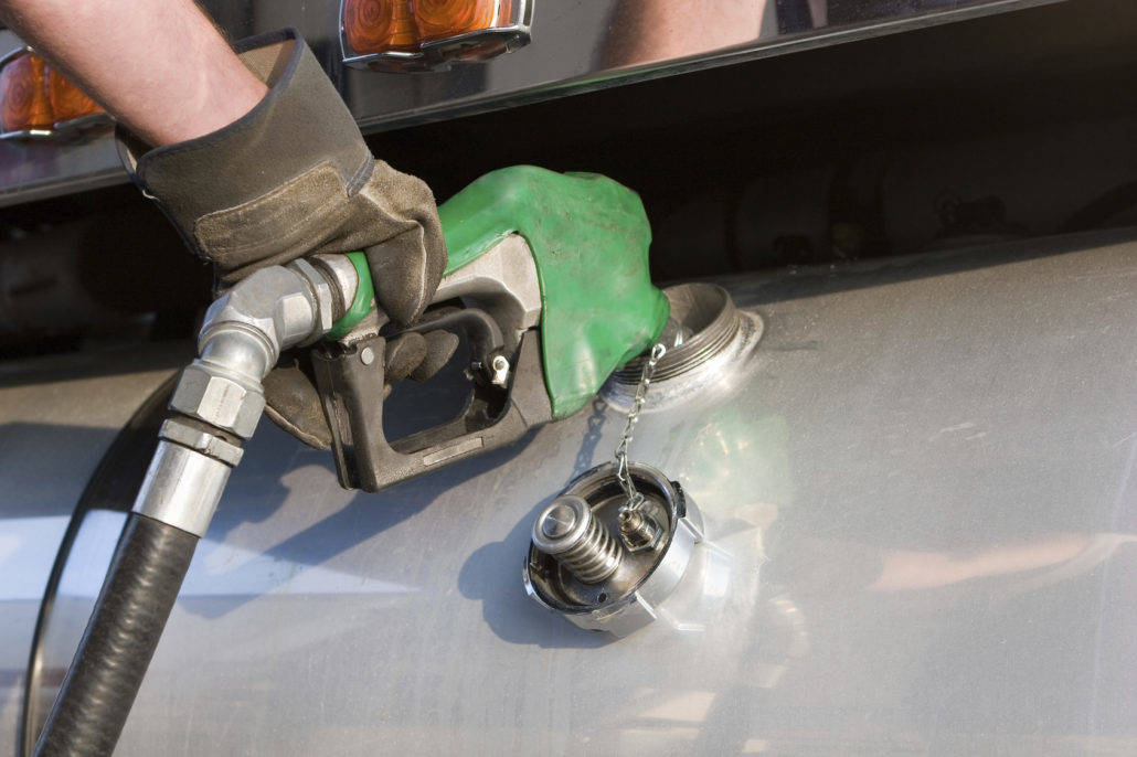 A person filling a gas tank using a pump